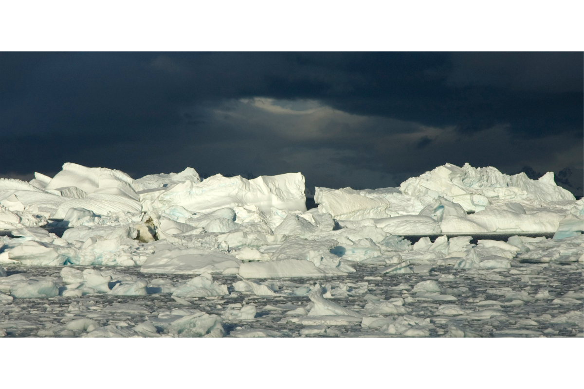 There is a block of ice stacked against a dark blue sky behind it.