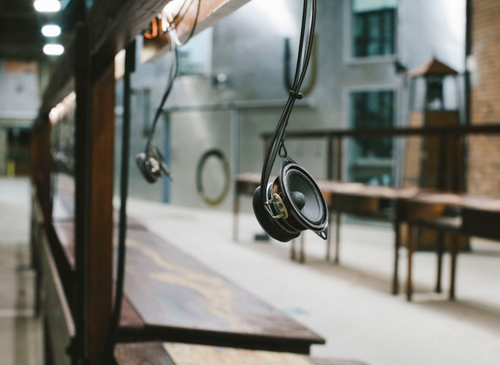 close up of microphone hanging on a wire above brown wooden desks