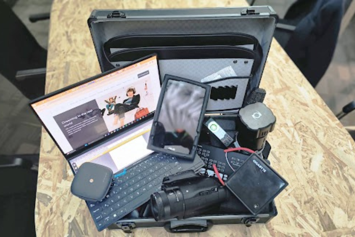 laptop, phone, camera, video cameras all on a desk