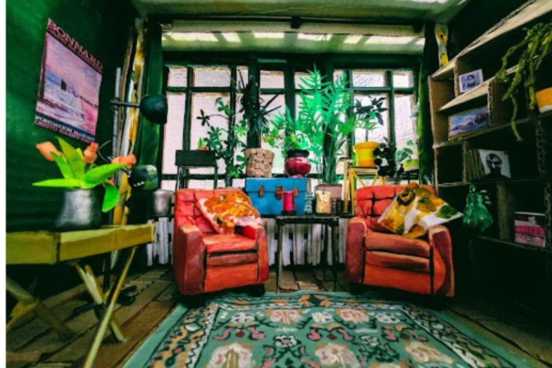 model of a home with orange chairs and large window